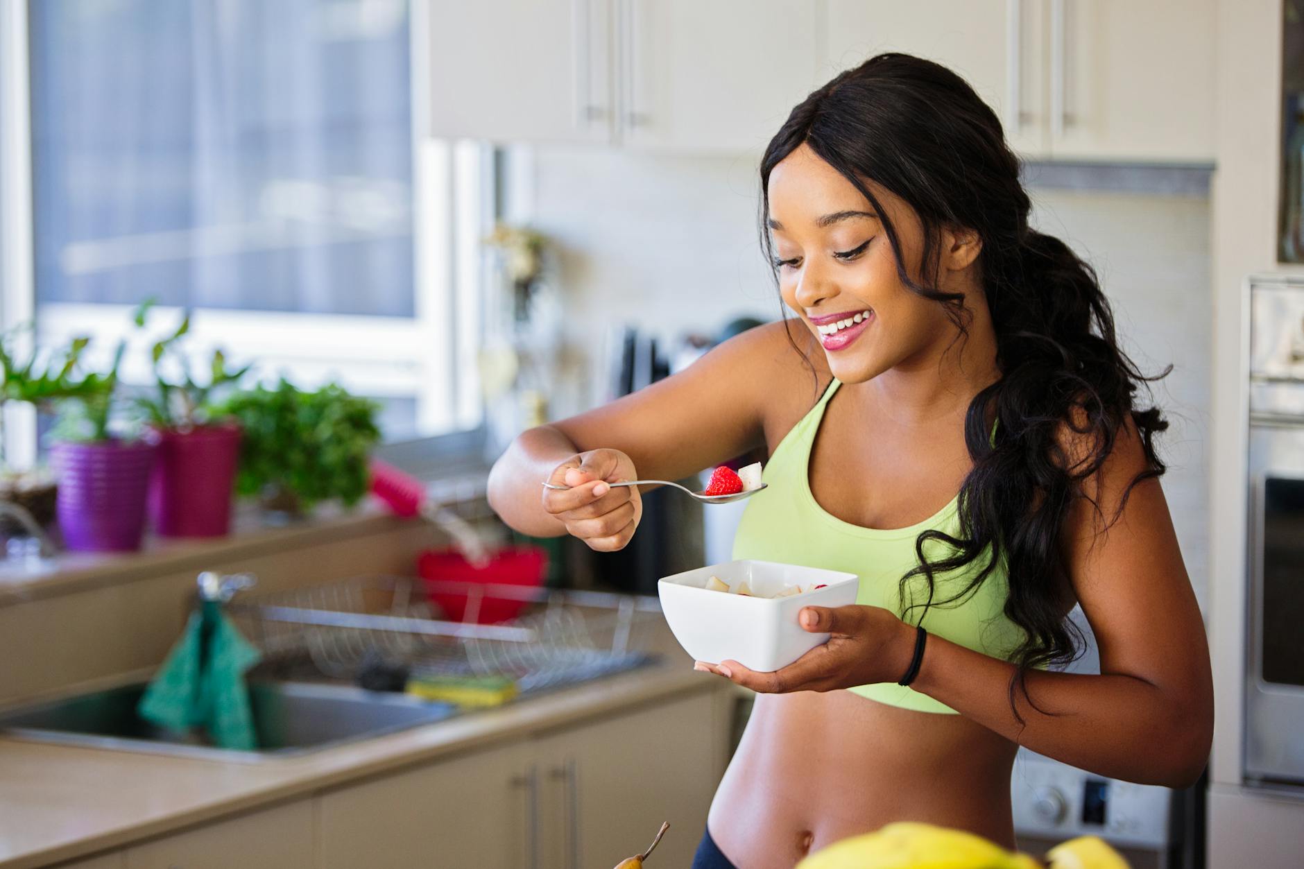 Woman Eating Strawberry in the Kitchen