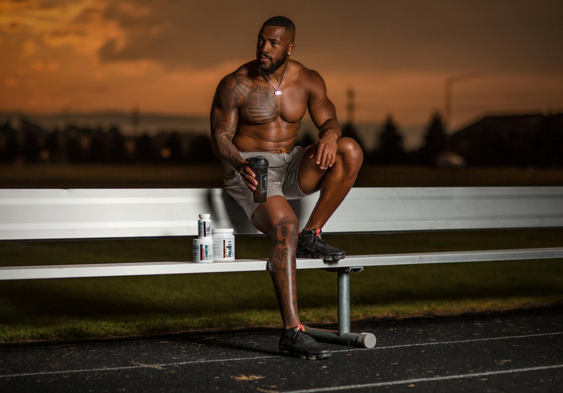 Sexy Athlete Sitting on Bench on Stadium on Sunset