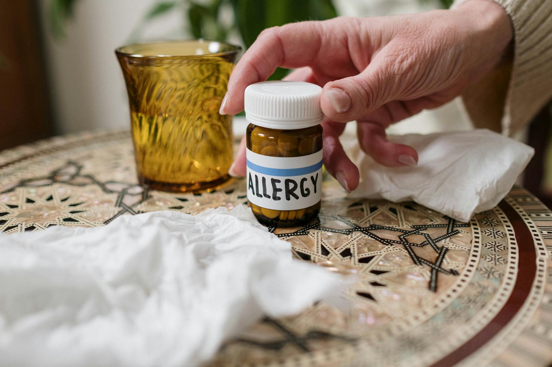 A close-up of allergy medication bottle on table with tissues, ideal for health themes.