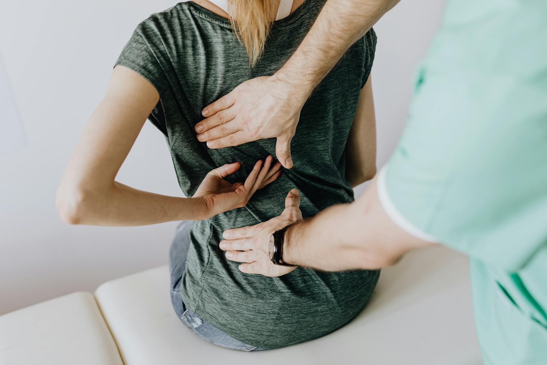 A chiropractor examining a patient's back to alleviate pain and discomfort.